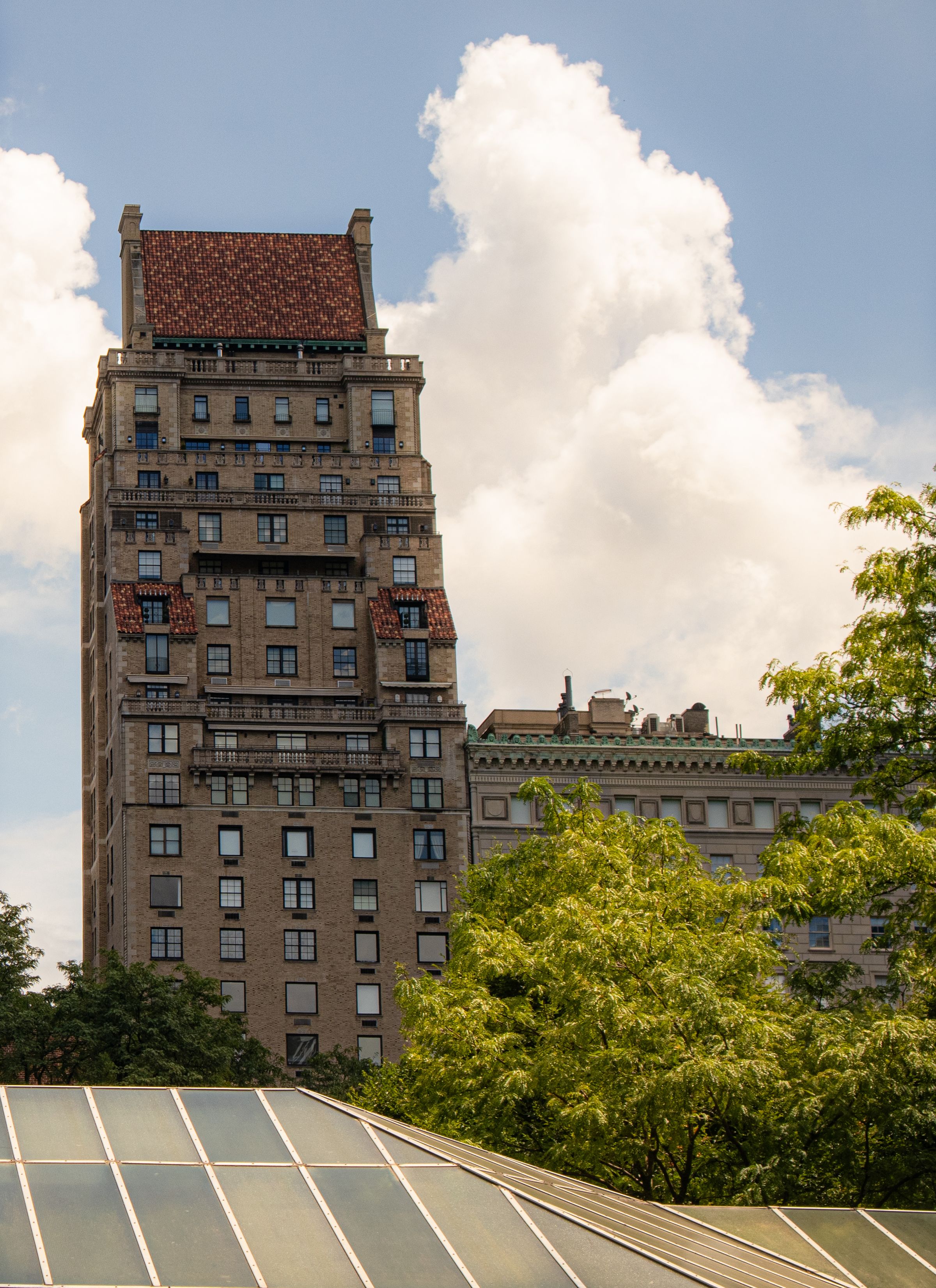 New York residential building rising above a tree-lined neighborhood.