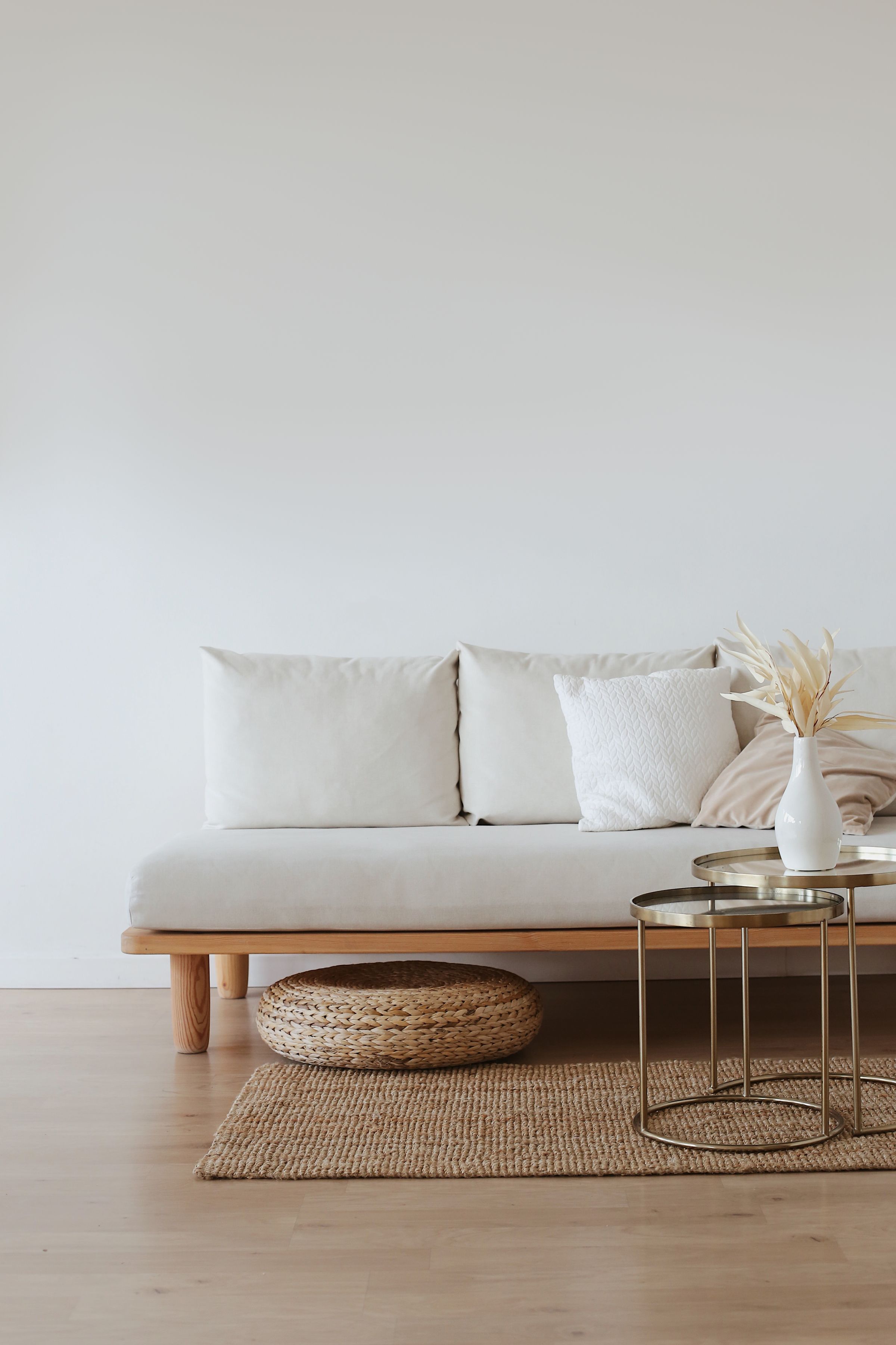 White minimalist living room with a low daybed sofa and natural textures.