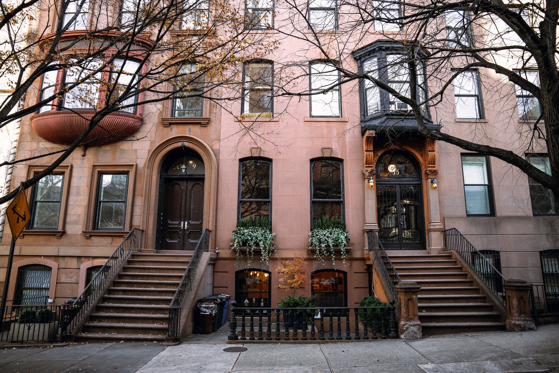 Pair of New York brownstone facades with stoops and bay windows